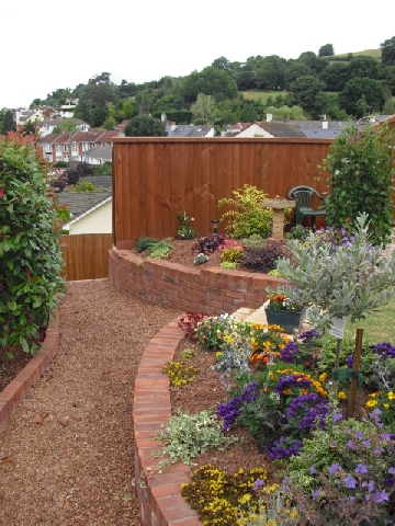 Curved Brick Retaining Wall with Pea Gravel Path.